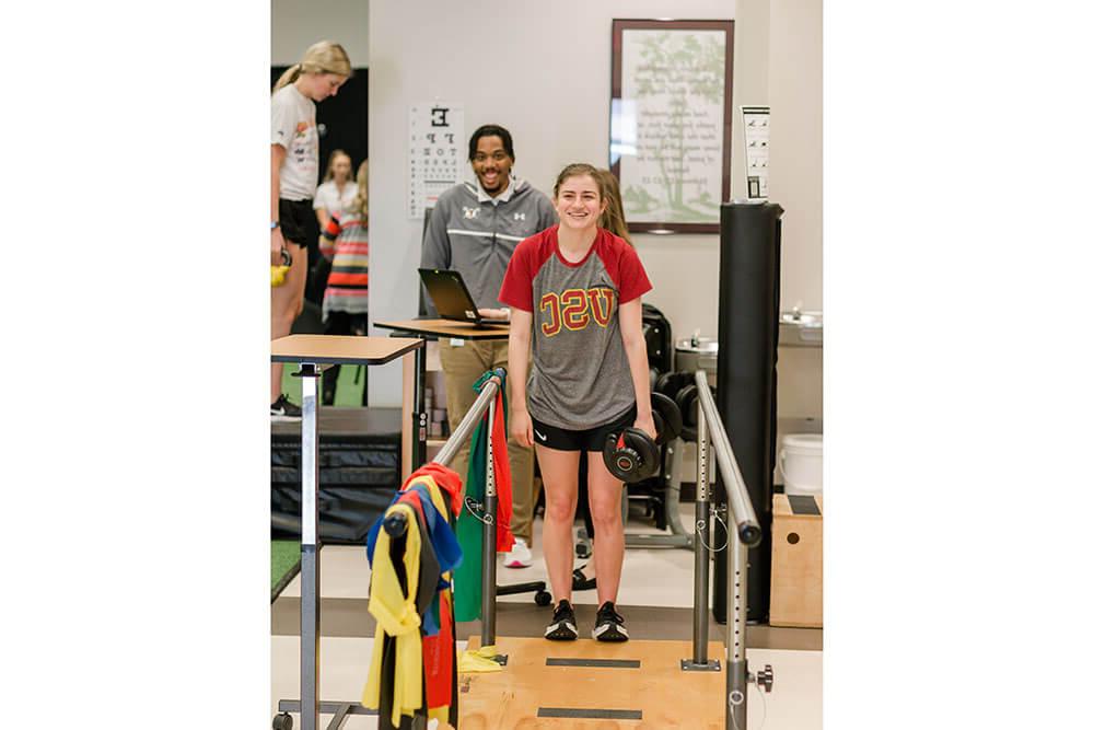 物理治疗专业的学生练习帮助病人学习走路