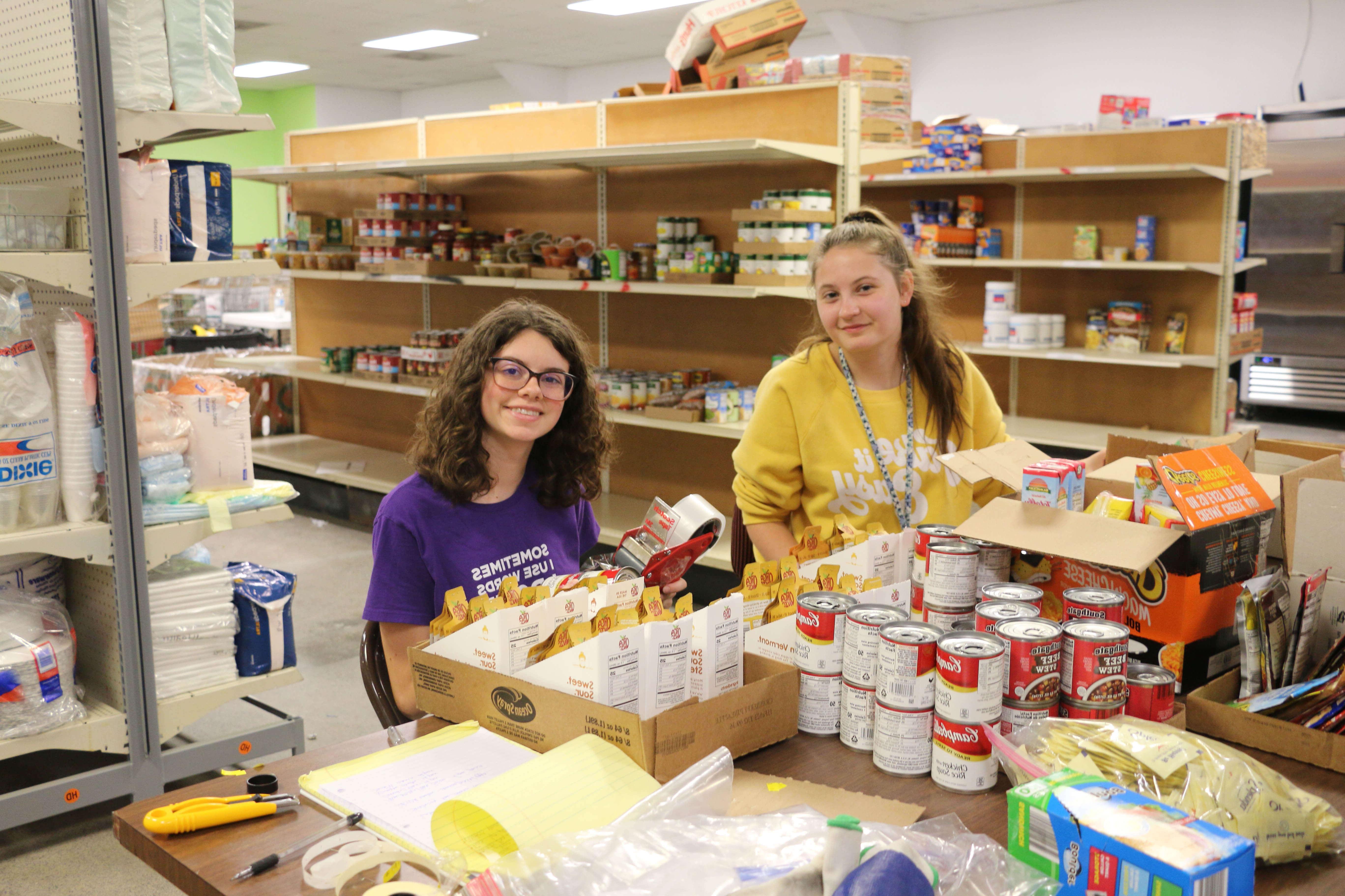 students serve by sorting canned food donations in food pantry